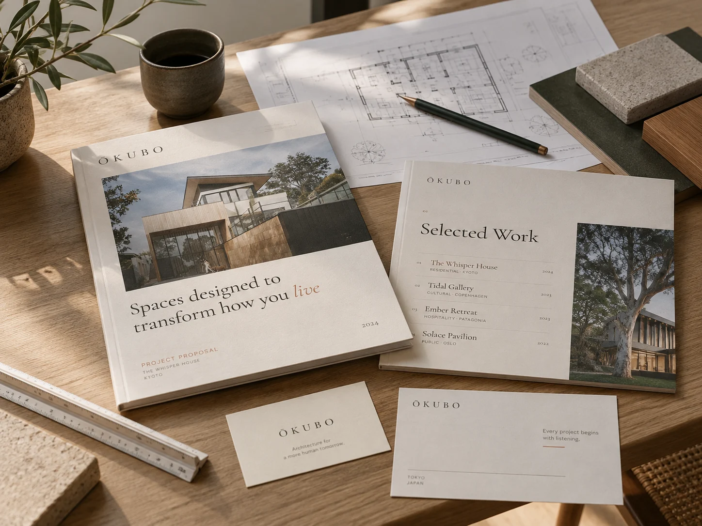 An Ōkubo project proposal and brochure on a desk with plans